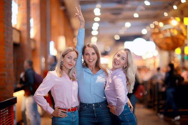 trzy młode kobiety w swobodnym stylu, dziewczyny w koszulach z długimi rękawami i dżinsach, piękne modelki