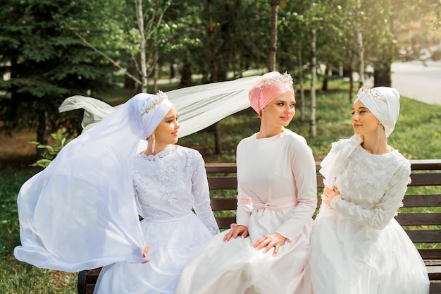 trzy piękne młode kobiety w świątecznych sukienkach muzułmańskich