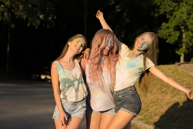 Trzy roześmiane blondynki przyjaciółki świętują festiwal Holi