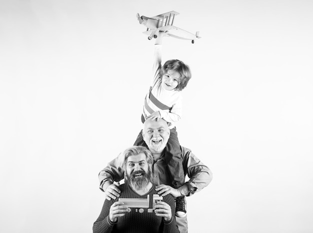 Trzy różne pokolenia w wieku dziadek, ojciec i syn dziecka bawiący się samolotem zabawkowym w studio i
