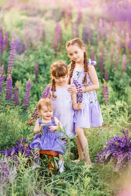 Trzy siostry z natury. Dzieci na łące z kwiatami