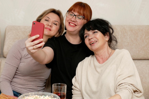 trzy śmiejące się kobiety biorą selfie do telefonu