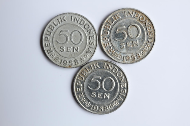 Trzy stare indonezyjskie 1958 stare monety 50 centów rupii na białym tle
