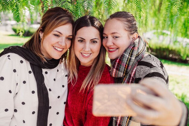 Trzy Uśmiechniętego Przyjaciela Wpólnie Robi Selfie W Plenerowym Parku, Dziewczyna Na Dobrze Z Brasami, Stylu życia Pojęcie