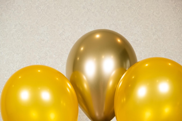 Trzy żółte balony na beżowym tle Urodzinowa organizacja świąt