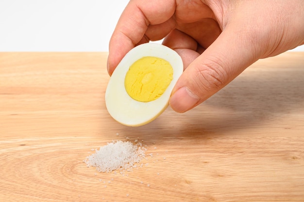 Trzymaj jajko na pół pokrojone na twardo i posyp je solą