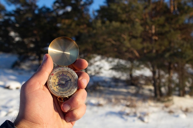 Trzymając kompas na tle zimowego lasu