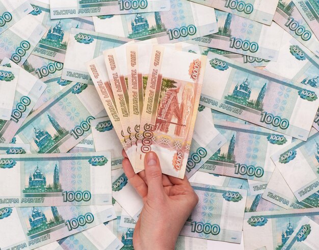 Trzymając w ręku banknoty pięciu tysięcy rubli rosyjskich na tle pieniędzy