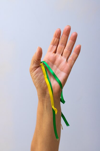 Trzymając Zielone I żółte Wstążki Flagi Brazylii Na Białym Tle. Flaga I Dzień Niepodległości Koncepcja Obrazu.