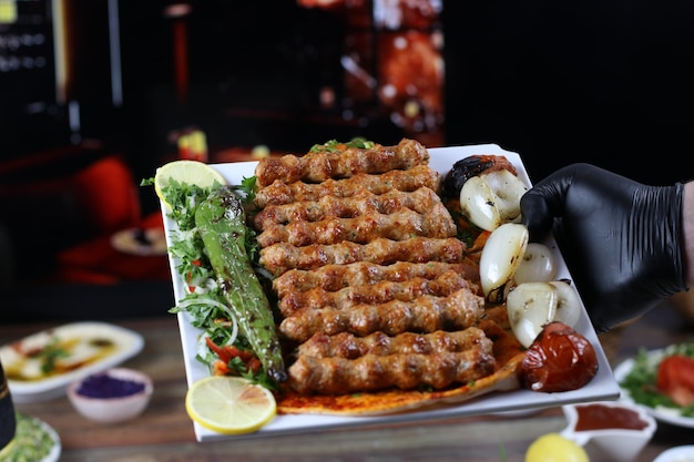 Zdjęcie trzymający szaszłyk z kurczaka z kebabem naczynie do serwowania z dodatkami i grillowanymi warzywami fantazyjne obiady 2