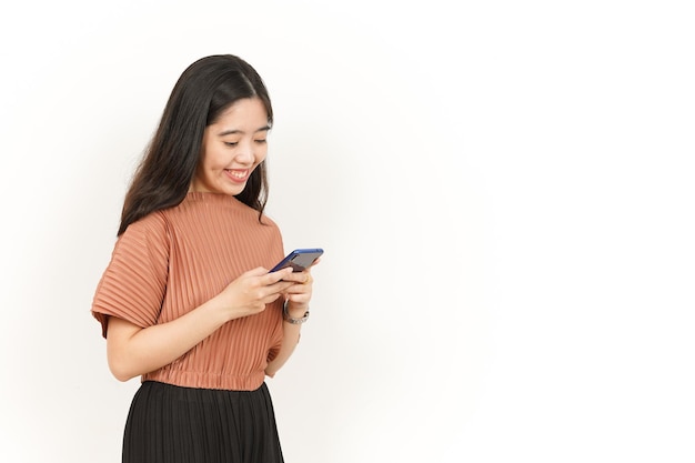 Trzymanie i używanie smartfona pięknej azjatyckiej kobiety na białym tle