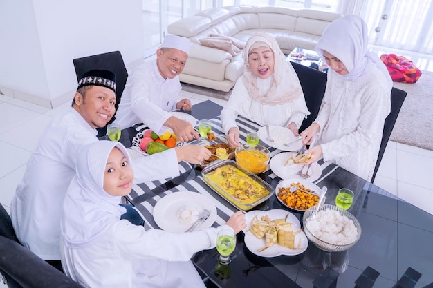 Trzypokoleniowa muzułmańska rodzina jedząca posiłki w Eid