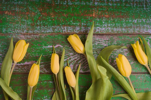 Tulipany na starym zielonym drewnianym tle widok z góry