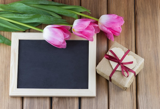 Zdjęcie tulipany z pustą tablicą i pudełkiem na prezent