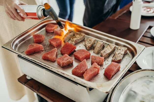 tuńczyk smażony na palniku gazowym w kuchni w restauracji