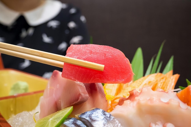 Tuńczyk w pałeczkach z japońskim sashimi na talerzu łódki