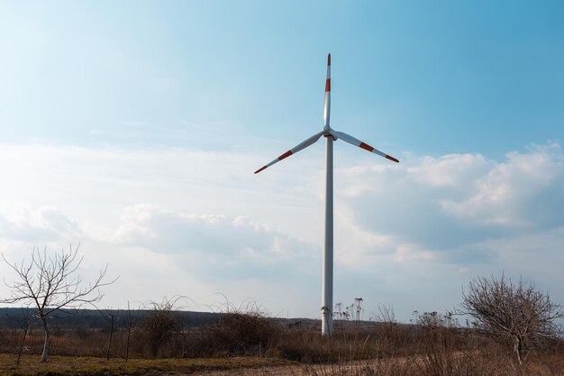 Turbina wiatrowa w polu Wiatrak generowania zielonej energii Tło błękitnego nieba