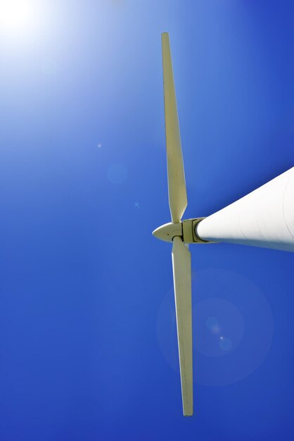 Zdjęcie turbina wiatrowa ze słońcem świecącym na szczycie