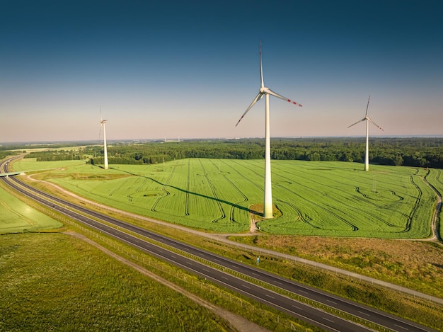 Turbiny wiatrowe i zielone pole w pobliżu autostrady widok z lotu ptaka