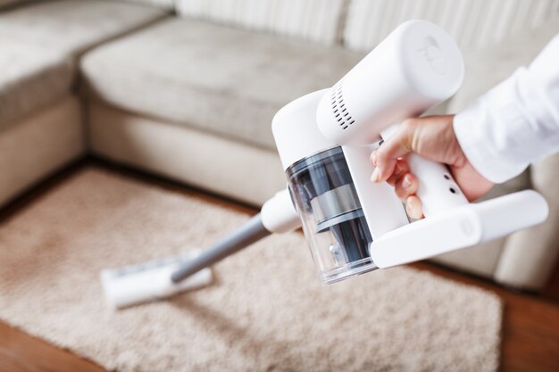 Zdjęcie turboszczotka odkurzacza bezprzewodowego czyści z bliska dywan w domu. nowoczesne technologie czyszczenia.