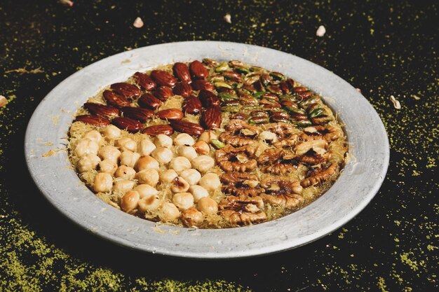 Zdjęcie turecki deser kunefe, kunafa, kadayif z pudrem pistacjowym i serem jedzonym na gorąco na słodko