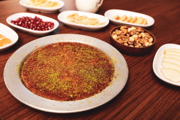 Turecki deser kunefe kunafa kadayif z pudrem pistacjowym i serem zjedzony na gorąco na słodko