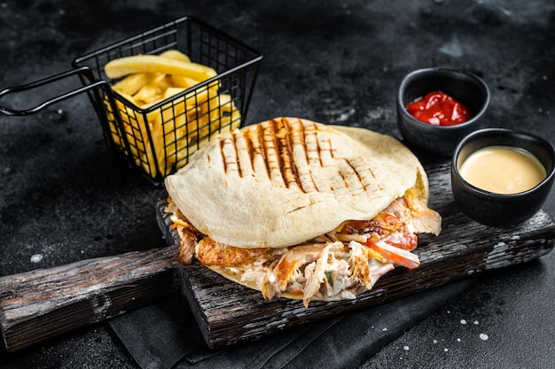 Turecki doner kebab w grillowanym chlebie pita z kurczakiem Czarne tło Widok z góry