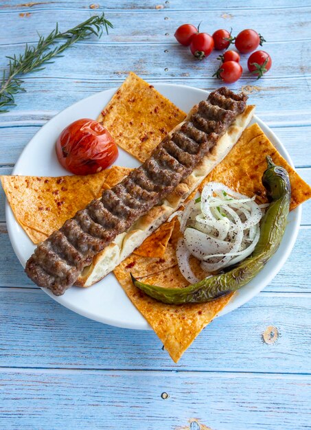 Turecki kebab adana z warzywami na talerzu