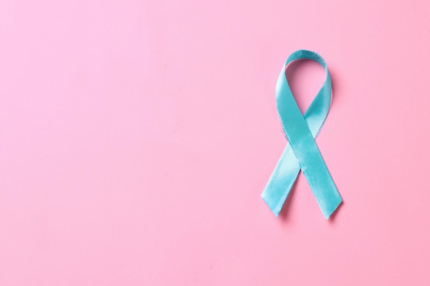 Turkusowa wstążka świadomości na różowym tle Wsparcie w walce z rakiem szyjki macicy