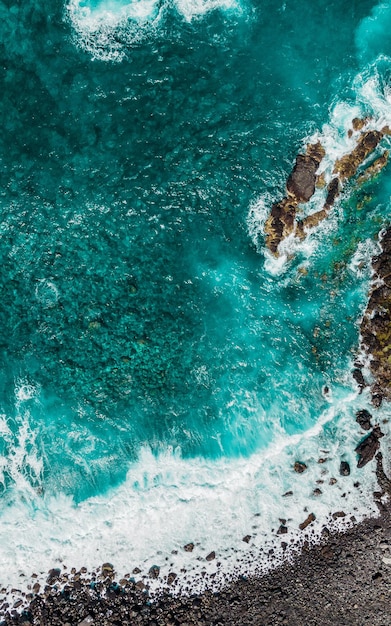 Turkusowe fale i piana morska znad wybrzeża oceanu na zdjęciu lotniczym drona Madera Portugalia