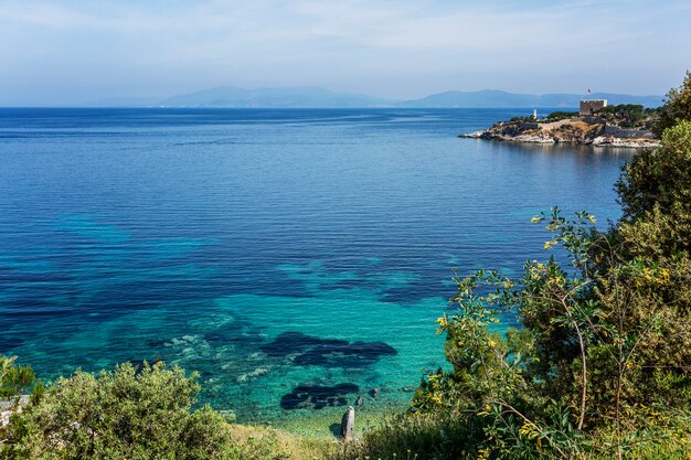 Zdjęcie turkusowe morze i zielone wybrzeże w jasny, słoneczny dzień. wspaniały widok na piękną zatokę. relaks i spokój. pocztówka. miejsce na tekst.