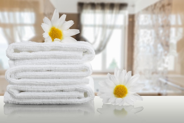 Turkusowe ręczniki spa gromadzą się na drewnie nad rozmytym tłem w łazience