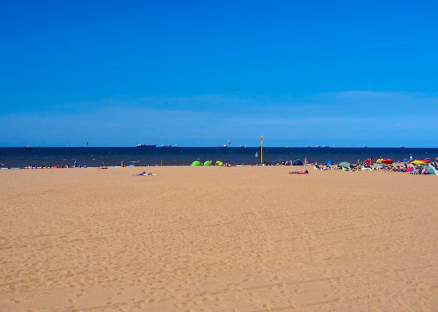 Turyści i ludzie na wakacjach nad Morzem Północnym na plaży Scheveningen Haga Holandia