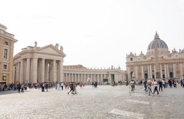 Turyści na Placu Świętego Piotra, arcydzieło architektury z kopułą Michała Anioła w Watykanie.