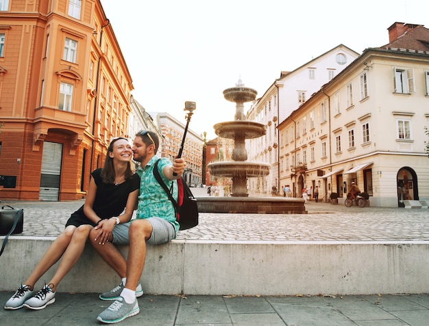 Turyści robiący zdjęcie selfie na kamerze akcji ruchu w starym centrum Lublany w Słowenii