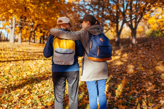 Turyści z plecakami spaceru w lesie jesienią Matka i jej córka dorosłych podróżujących razem