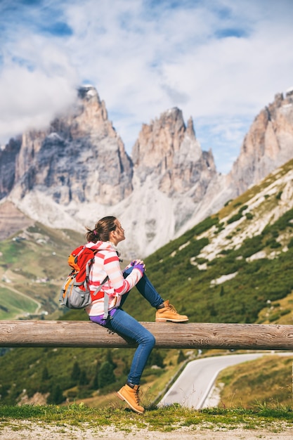 Turysta dziewczyna siedzi i patrząc na zaśnieżone góry. Dolomity, Włochy.