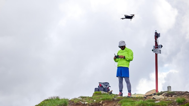 Zdjęcie turysta facet wypuszcza drona w góry