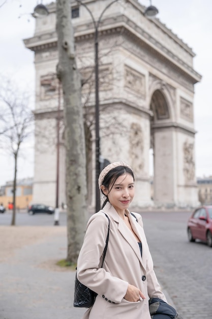 Turysta kobieta na tle słynnego Łuku Triumfalnego Zima lub jesień w Europie Paryż Francja