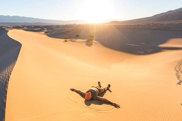 Turysta na piaszczystej pustyni. Czas wschodu słońca.
