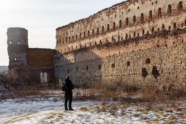 Turysta patrzy na mur zamku w Starym Siole, obwód lwowski, Ukraina