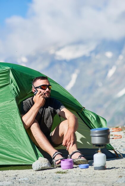 Turysta rozmawia przez radio podczas odpoczynku w górach