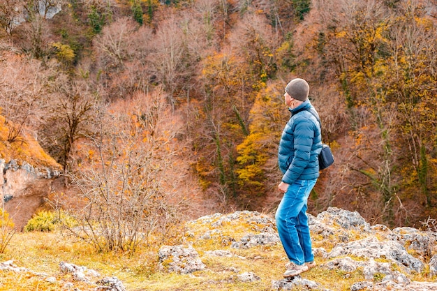 Turysta spaceruje po górach jesienią i patrzy na wąwóz poniżej Podróże i turystyka