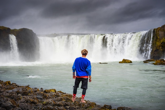 Turysta stojący przy wodospadzie Godafoss na Islandii