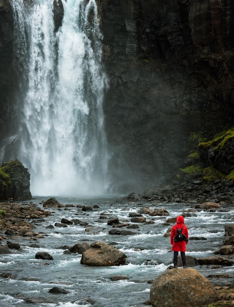 Turysta w czerwonej kurtce patrzy na wodospad Gufu. Islandia. Krajobraz Islandii.