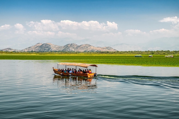 Zdjęcie turysta w łodzi na jeziorze skadar na granicy albanii i czarnogóry