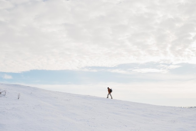 Turysta w ośnieżonych górach Zimowy krajobraz z alpinistą na tle błękitnego nieba