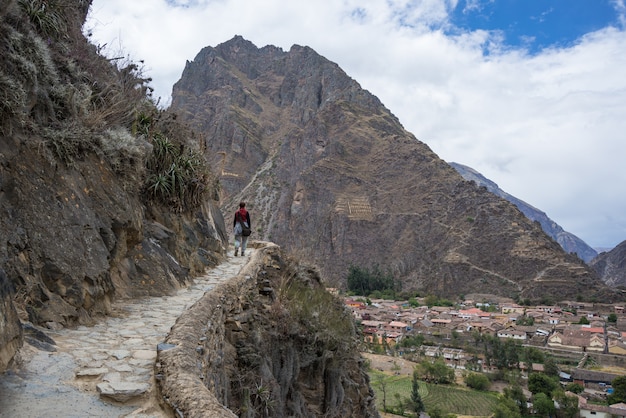 Turysta zwiedzający szlaki Inków i stanowisko archeologiczne w Ollantaytambo, Święta Dolina, cel podróży w regionie Cusco, Peru. Wakacje i przygody w Ameryce Południowej.
