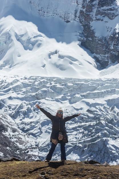 Zdjęcie turystka otwiera ręce przed śnieżną górą koncepcja podróży kopiuj przestrzeń