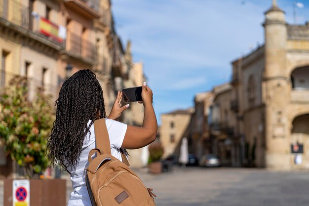 Zdjęcie turystyczna dziewczyna na wakacjach robiąca zdjęcia telefonem w słynnej wiosce ciudad rodrigo w salamance